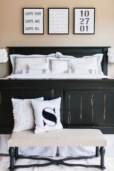 a black and white bedroom with pictures on the wall above it, along with a bench