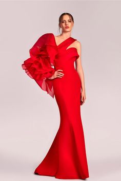 Make a striking impression in this stunning red gown, expertly crafted from luxurious crepe that beautifully contours your curves before flowing into an elegant mermaid silhouette. The one-shoulder design features a dramatic organza sleeve, adorned with voluminous ruffles that introduce a whimsical elegance. A daring thigh-high slit adds an element of confidence and allure. Ideal for making a grand entrance, this dress perfectly embodies sophistication and bold femininity. Long Outfit, Organza Sleeves, Red Gowns, Mermaid Silhouette, Grand Entrance, One Shoulder Dress, Ruffles, Entrance