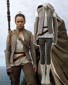 a woman standing next to a man in star wars outfit on top of a cliff