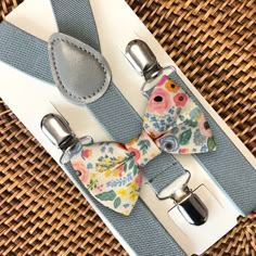 This floral bow tie & grey suspenders set is a great choice for a spring bow tie, ring bearer outfit, Easter, mens bow tie, spring wedding, groomsmen, or any other special occasion.  **Please Specify**   Bow Tie Only (w/ Clip or Neck Strap), Suspenders Only, or Bow Tie Only & Susp (Bow Tie and Suspenders) SUSPENDERS- One Pair of our Quality Suspenders BOW TIE - One Bow Tie on White Adjustable STRAP or Alligator CLIP **CLIP ON Bow Ties are Recommended/Suitable for Children Only *Sizing: Please Check Measurements Before Ordering *Note: If your gentleman wears larger clothing for his age, we recommend going by the clothing size to be safe. Any other questions on this, please just ask!  Small: 6 months- 6 years Medium: 7 years- 12 years Adult: 13 years- Up To 6ft tall Big & Tall: Adults Over 6 Spring Wedding Groomsmen, Bow Tie Ring, Spring Bow, Bow Tie Groomsmen, Groomsmen Suspenders, Grey Suspenders, Bright Wedding Colors, Tie Ring, Tie And Suspenders