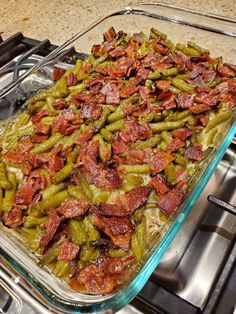 green beans and bacon in a glass casserole dish on top of the stove