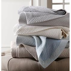 several folded blankets stacked on top of each other