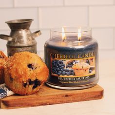 blueberry muffins next to a candle on a cutting board