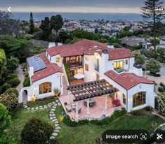 an aerial view of a house with solar panels on the roof and landscaping around it