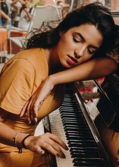 a woman leaning on the edge of a piano