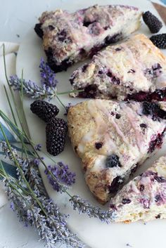 blueberry scones on a plate with lavender sprigs and blackberries next to them