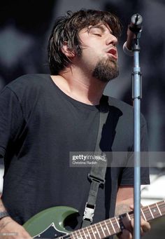 a man with his eyes closed while playing guitar