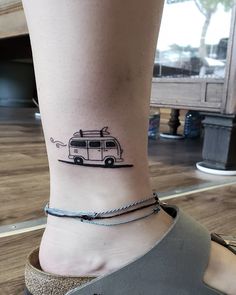 a woman's foot with a small camper tattoo on her left side ankle