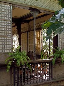 a balcony with potted plants on the balconies and an iron fence around it