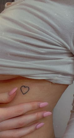 a woman's stomach with a heart tattoo on it