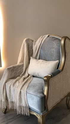 a chair that is next to a wall with a blanket on it's back