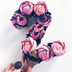 a person holding some pink flowers in their hand