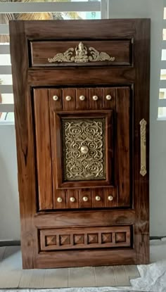 a wooden door with ornate carvings on the front and side panels, along with decorative knobs