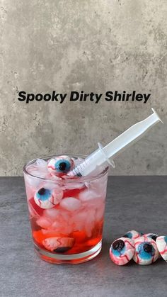 spooky dirty shirly in a glass with ice and blueberries