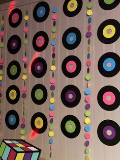 colorful circles hanging from the ceiling next to a rubikt cube on a string