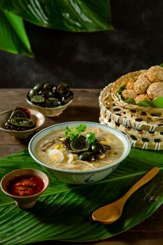 a bowl of soup with olives and crackers on a tray next to it