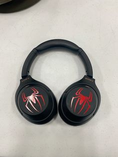 two black and red spider - man headphones sitting on top of a white counter