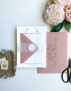 the wedding stationery is laid out on top of the table next to some flowers