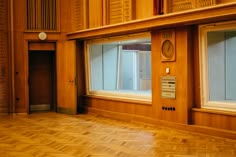 an empty room with wood paneling and windows