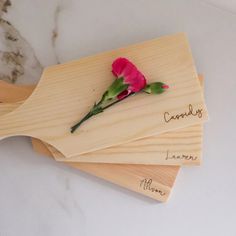 three wooden coasters with flowers on them sitting on a marble counter top, one is for mom and the other is for someone's name