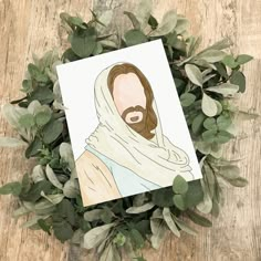 a card with an image of jesus on it surrounded by green leaves and greenery