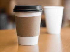 two coffee cups sitting on top of a wooden table