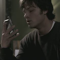 a young man is looking at his cell phone