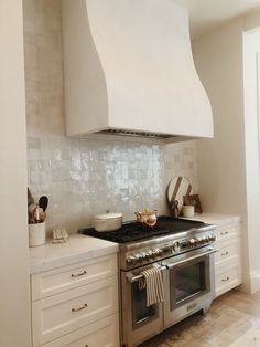 a stove top oven sitting inside of a kitchen next to a wall mounted range hood