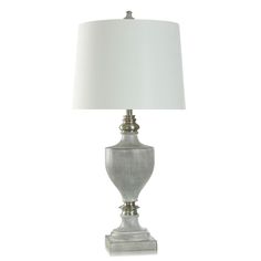 a silver lamp with a white shade on it