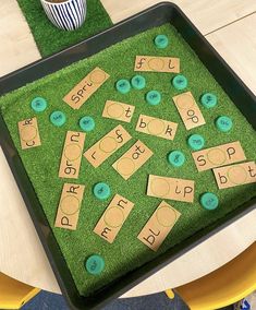 there is a tray that has some letters on it and grass in front of it