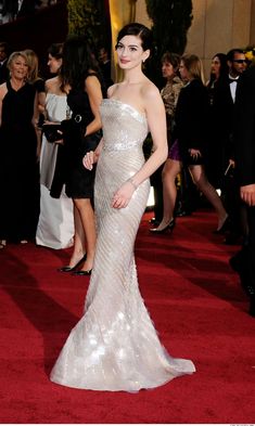 a woman in a strapless dress on the red carpet at an oscars event