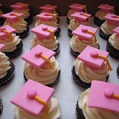 cupcakes decorated with pink frosting and graduation caps