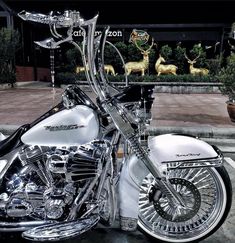 a white motorcycle parked in front of a building with deer on it's side