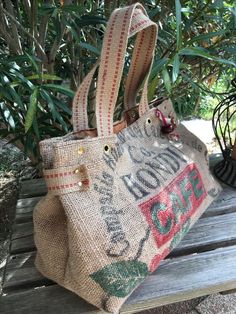 a burluck bag sitting on top of a wooden bench next to a tree