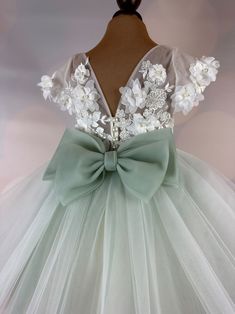 a dress with white flowers and green ribbon