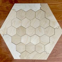 a wooden hexagonal board on a wood surface with holes in the middle to make it look like hexagons