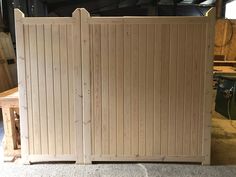 a pair of wooden gates sitting next to each other on top of a cement floor