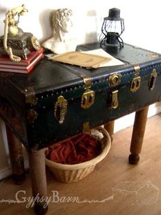 an old trunk is sitting on a table with books and other items around it,