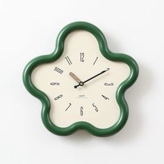 a green and white clock with numbers on the face against a white background, it appears to be in mid - afternoon