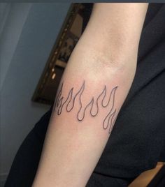 a woman with a tattoo on her arm that has flames coming out of the back