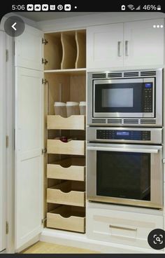 an oven and microwave in a white kitchen with drawers on either side of the oven