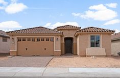 a brown house with two garages and no one in the front yard on a sunny day