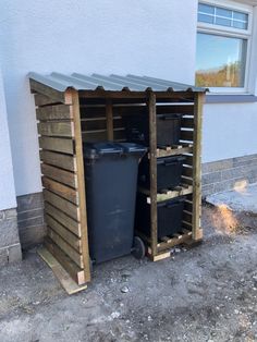 two trash cans are sitting in the side of a building