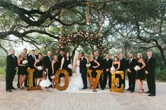 a large group of people standing in front of a love sign