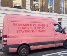 a pink van is parked on the side of the road in front of a building