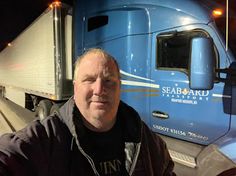 a man standing in front of a semi truck