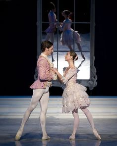 two ballerinas standing next to each other in front of a mirror