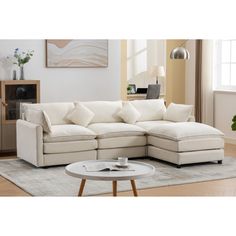 a living room with a sectional couch and coffee table in front of the sofa is white