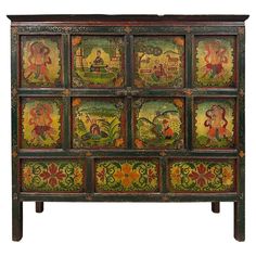 an ornately decorated chest with paintings on the front and side panels, all painted in different colors