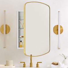 a bathroom sink with a mirror and two gold faucets on the wall next to it